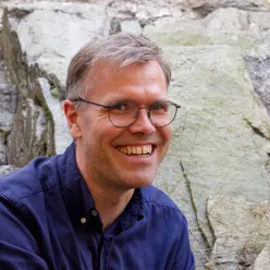 En mann som smiler til kameraet