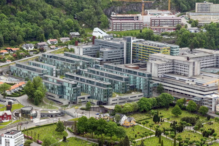 Flyfoto av sykehuscampus med mange bygninger og bybanestopp.