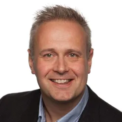 En mann som smiler til kameraet