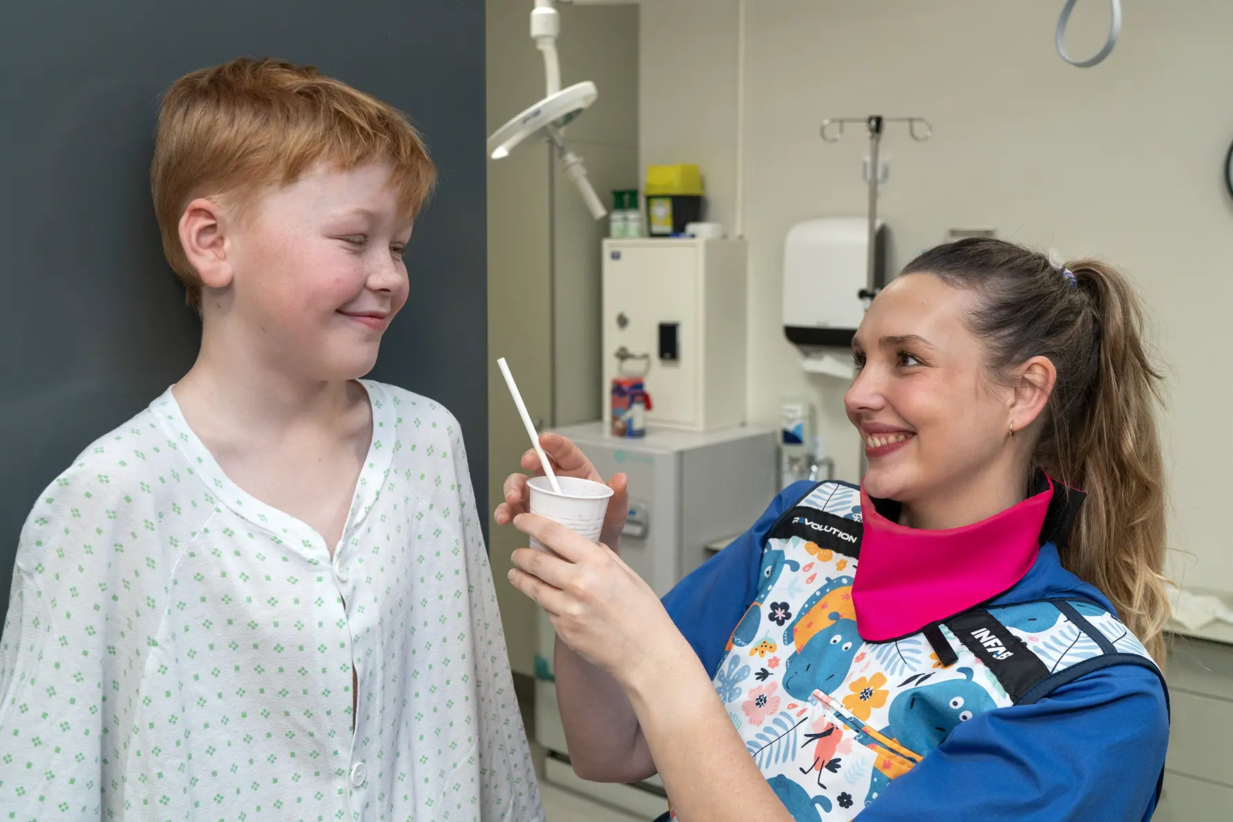 Gutt får drikke av radiograf og står ved et røntgenapparat