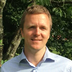 En mann som smiler til kameraet