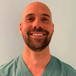 En mann som smiler til kameraet