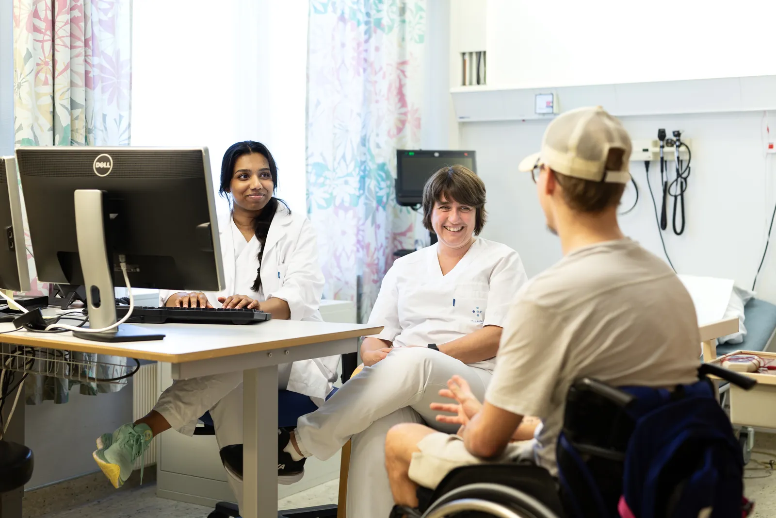 Behandlere og pasient i oppfølgingssamtale