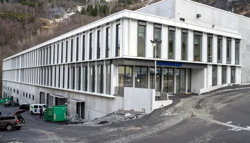 En hvit bygning med parkeringsplass