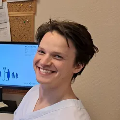 En mann som smiler foran en datamaskin