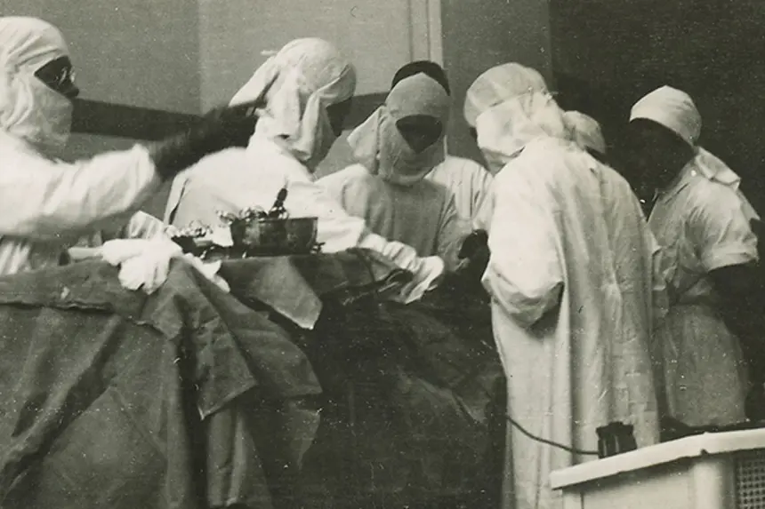 Leger og sykepleiere rundt operasjonsbord. Foto
