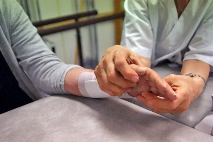 Fysioterapeut behandler hånden til pasient. Foto