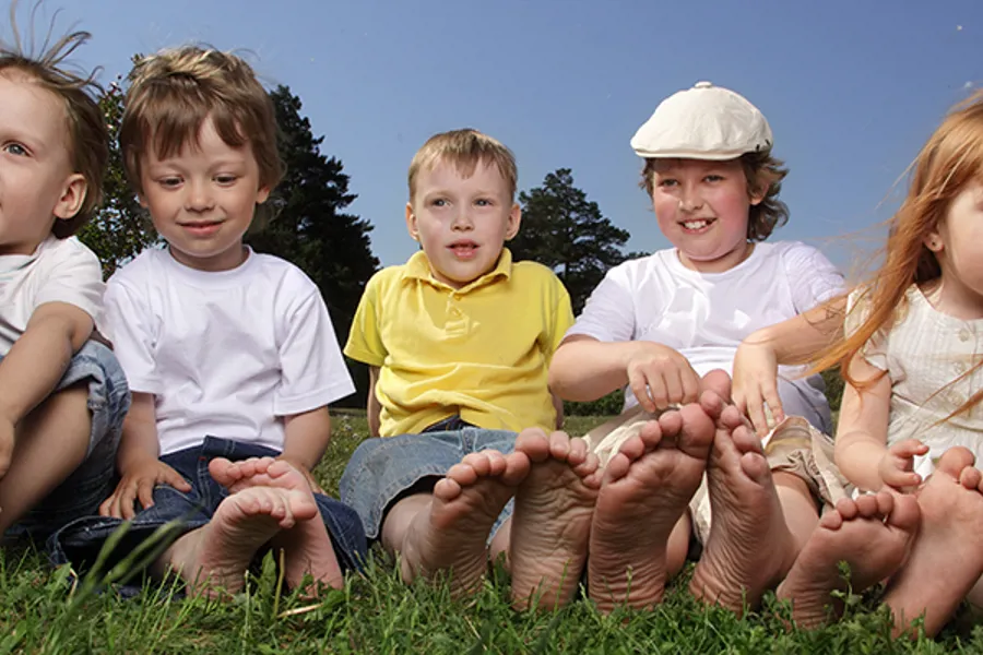 En gruppe barn som sitter på gress
