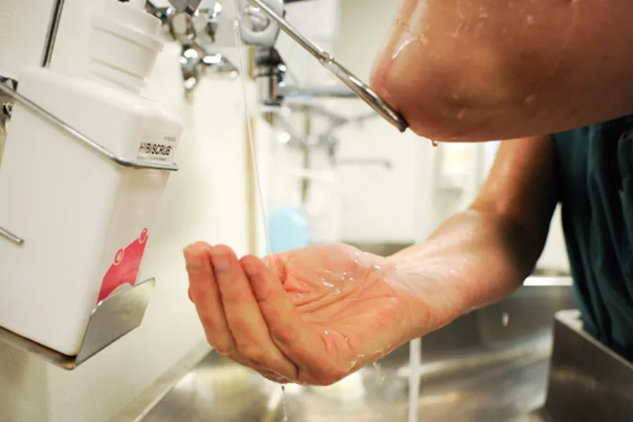 En person vasker hendene i vasken