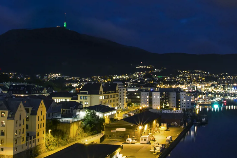 Utsiktsbilde på kvelden med utsikt mot Bergen og Møhlenpris mot silhuetten av Ulriken sett fra Puddefjordsbroen. Foto