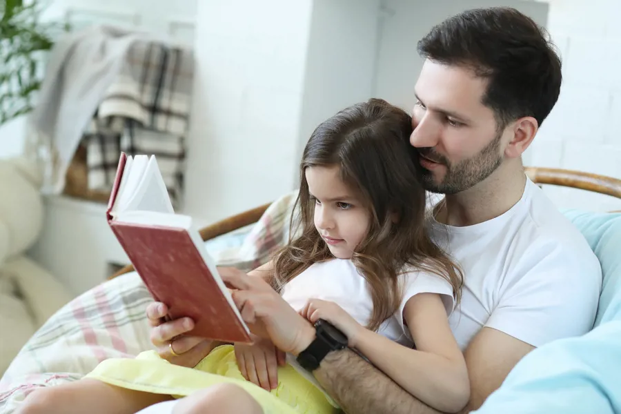 far og barn leser bok