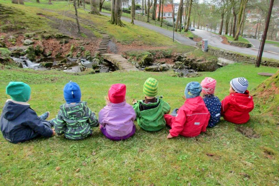 En gruppe barn som sitter på gresset