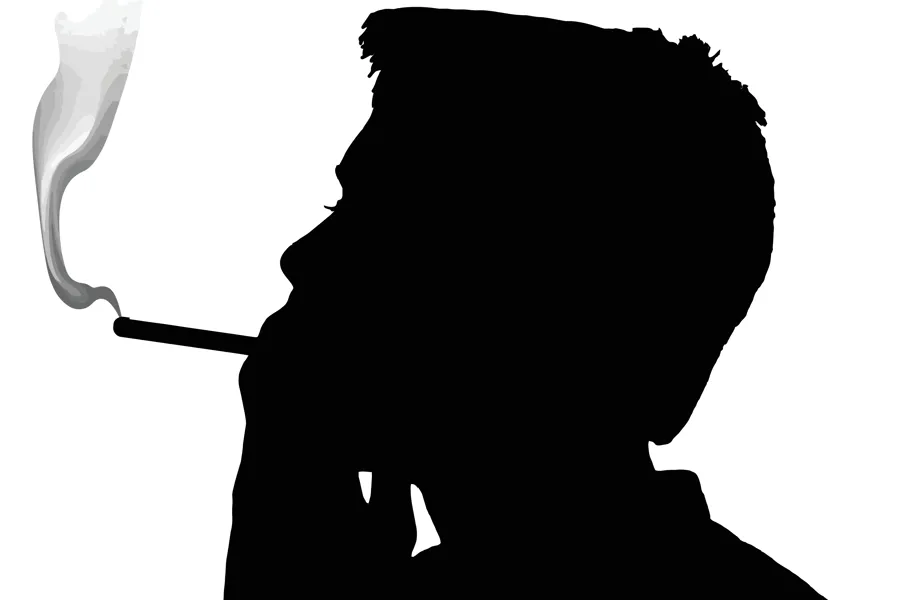En silhuett av en person med en sigarett i munnen