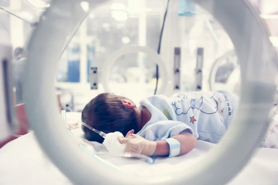 En baby som ligger i en inkubator