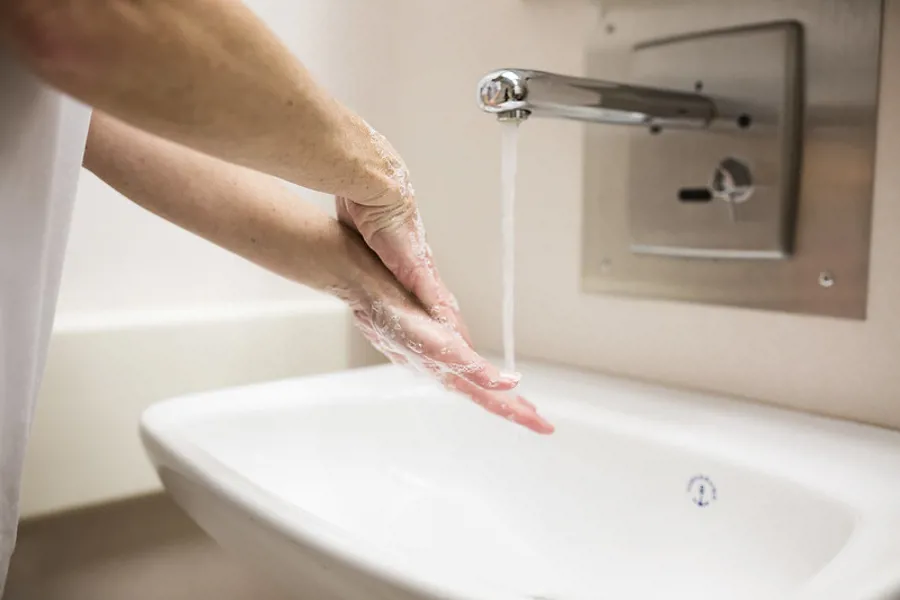 En person vasker hendene i en vask