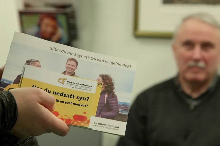 Brosjyrer fra Norges Blindeforbund vises frem til en person