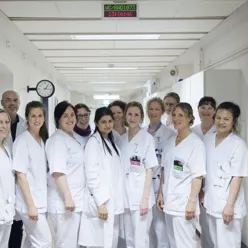 Gruppebilde av tilsette i sjukehuskorridor.