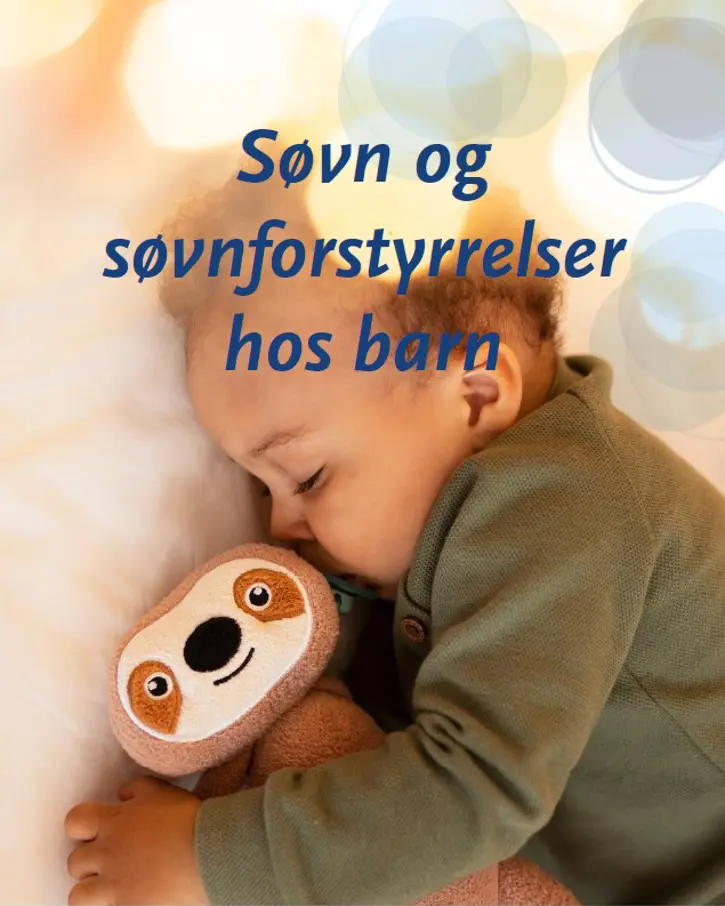 En baby som sover med et kosedyr