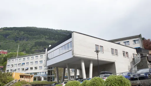 En hvit bygning ved foten av et fjell