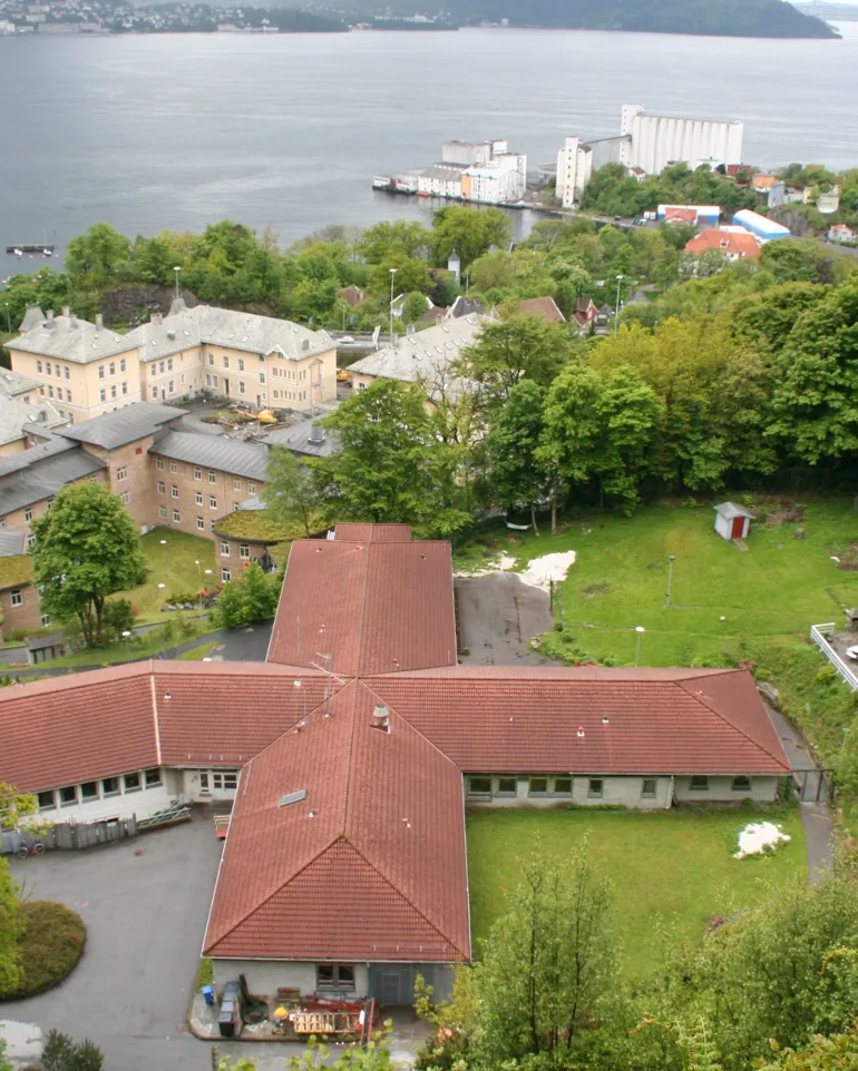 En bygning med rødt tak ved en vannmasse