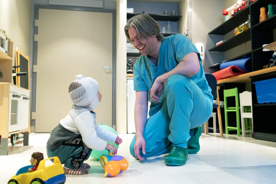 Bilde av Stian Kreken Almeland med et lite barn med bandasjer