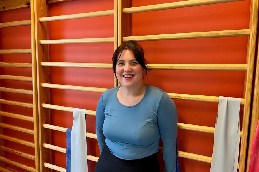En person som står foran en rød vegg