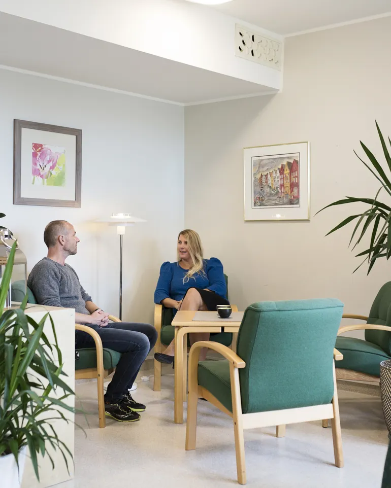 to personer sitter på venterommet
