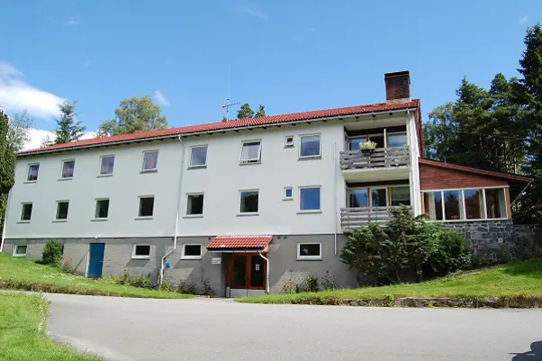 En stor hvit bygning med rødt tak