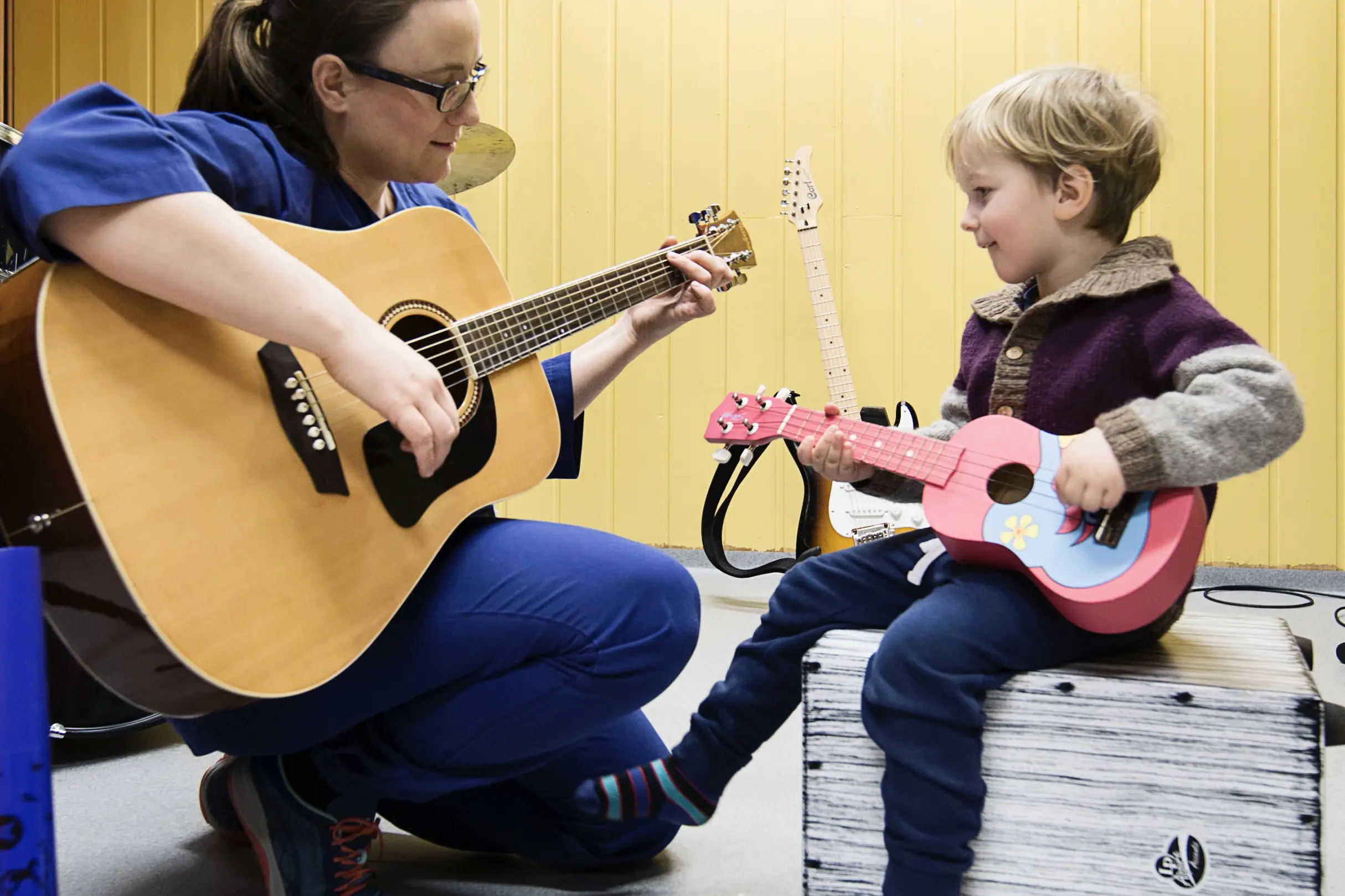 musikkterapeut og gutt spiller på hver sin gitar