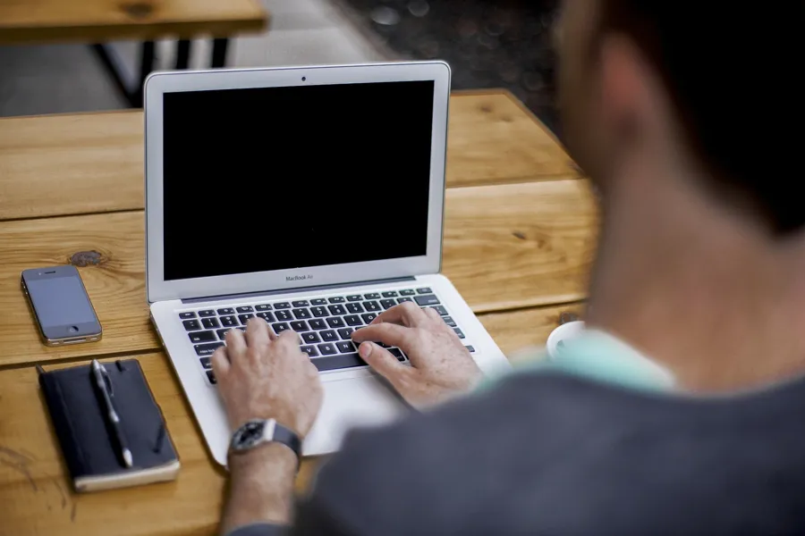 foto av mann som jobber på pc og skriver på tastatur